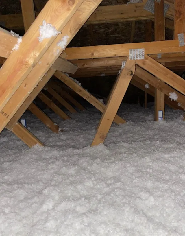 Freshly blown-in insulation filling an attic space to R-49 code