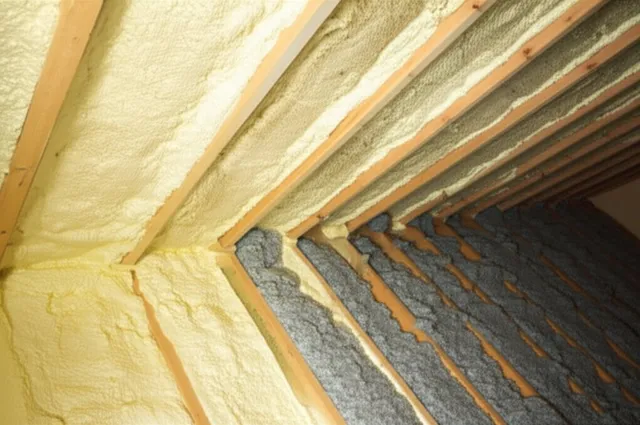 Spray foam insulation applied between attic rafters alongside blown-in cellulose insulation on the attic floor in a Seattle-area home