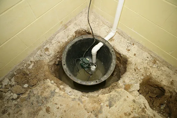 Sump pump basin being installed in crawl space